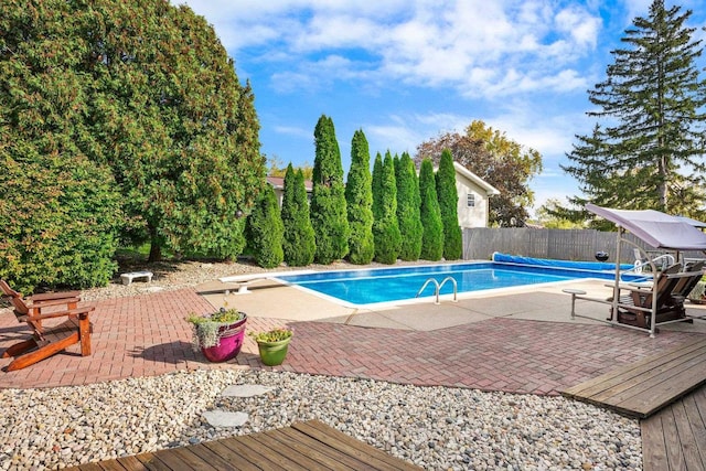 view of swimming pool featuring a diving board and a patio