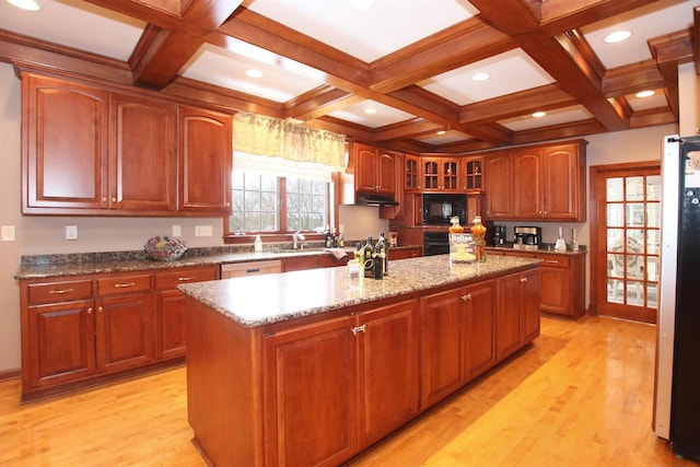 kitchen with coffered ceiling, a kitchen island, beam ceiling, black appliances, and light wood-type flooring