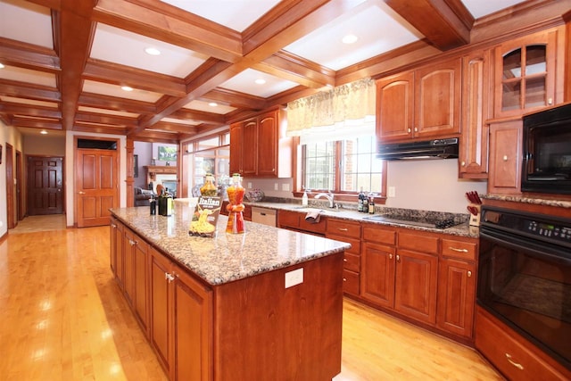 kitchen featuring black appliances, light wood-type flooring, a center island, coffered ceiling, and beamed ceiling