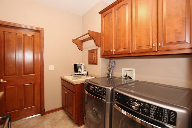 laundry room featuring light tile patterned floors, sink, separate washer and dryer, and cabinets