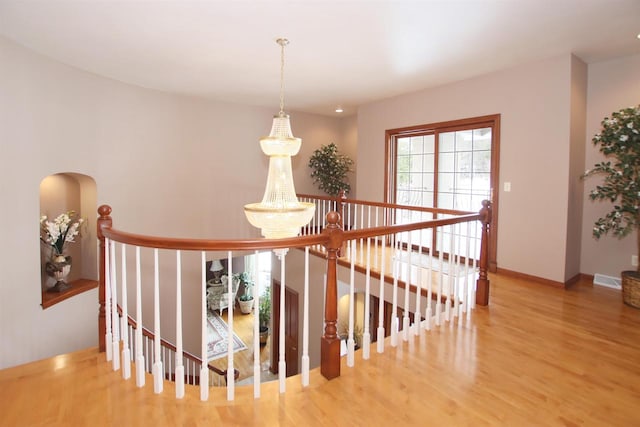 stairs featuring a notable chandelier and hardwood / wood-style flooring