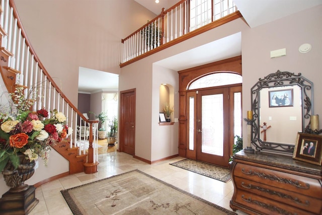 entrance foyer with a towering ceiling and light tile patterned floors