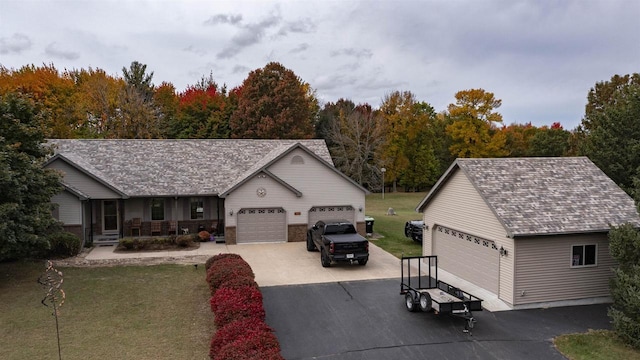 view of front facade featuring a porch, a front yard, and a garage