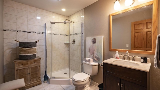 bathroom featuring vanity, tile patterned flooring, toilet, and an enclosed shower