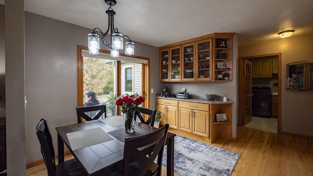 dining area with a notable chandelier and light hardwood / wood-style flooring