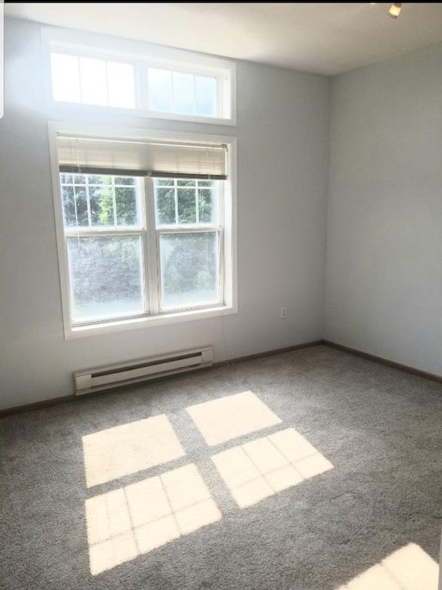 empty room featuring carpet flooring and a baseboard heating unit