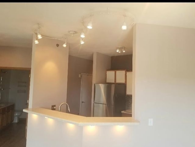 kitchen featuring decorative backsplash, stainless steel refrigerator, and sink