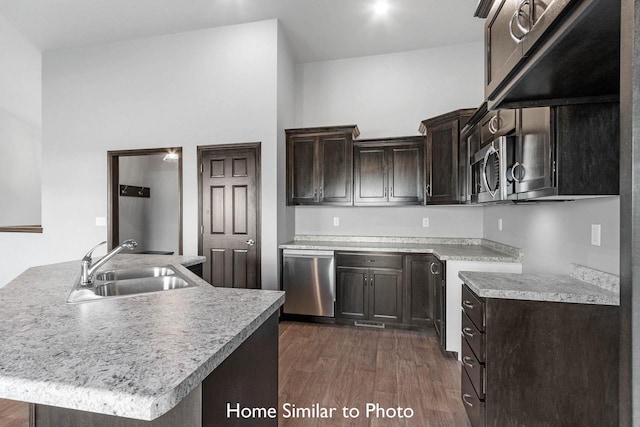 kitchen with a center island with sink, sink, stainless steel appliances, and dark hardwood / wood-style flooring