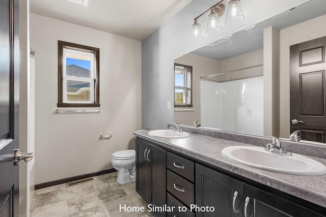 bathroom featuring walk in shower, vanity, plenty of natural light, and toilet