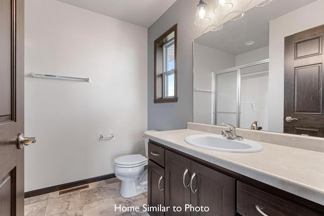 bathroom with an enclosed shower, vanity, and toilet