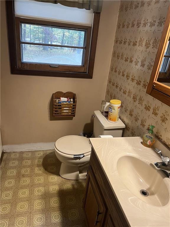 bathroom with a healthy amount of sunlight, vanity, and toilet