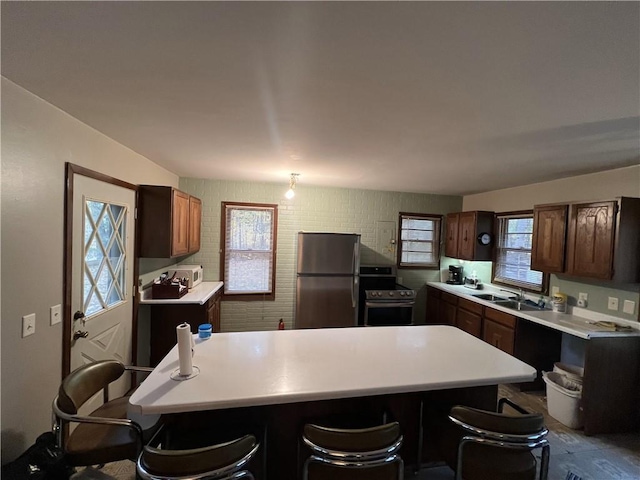 kitchen with a breakfast bar area, appliances with stainless steel finishes, sink, and a center island