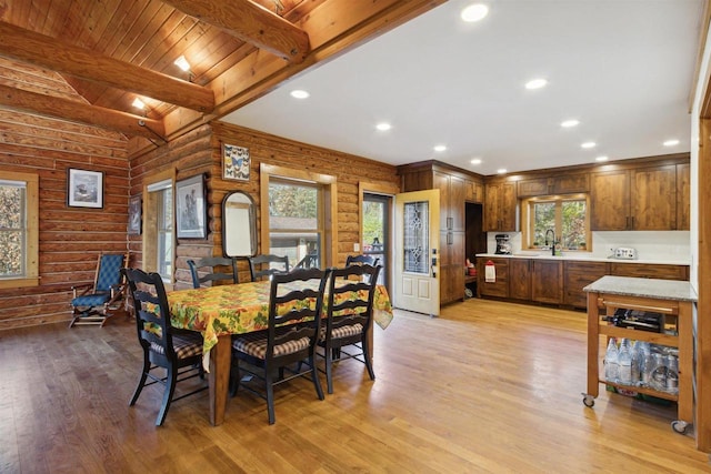 dining area featuring light hardwood / wood-style floors, beamed ceiling, sink, and wooden ceiling