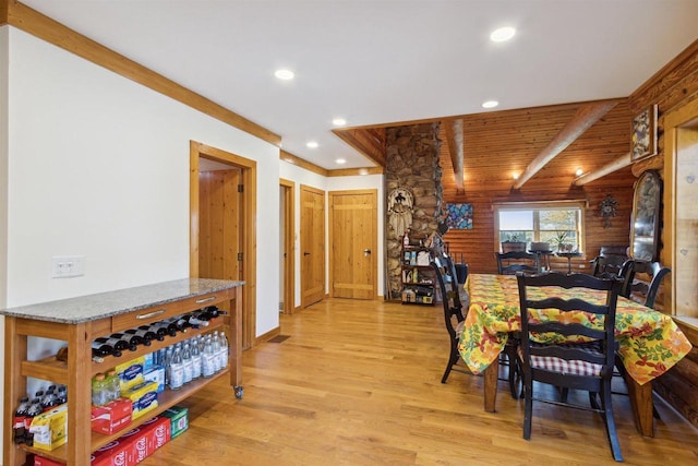 dining room featuring beamed ceiling, light wood-type flooring, and wooden ceiling