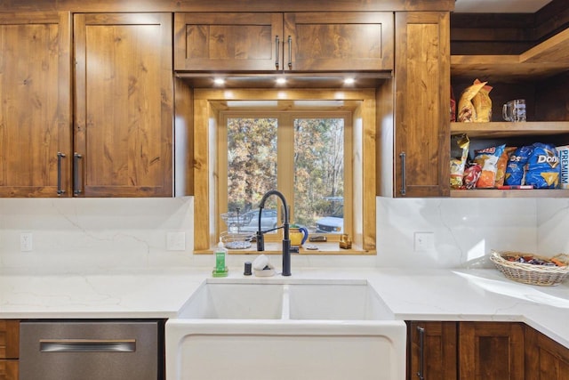 kitchen featuring stainless steel dishwasher, decorative backsplash, sink, and light stone counters