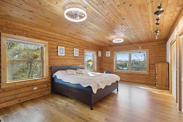 bedroom featuring light hardwood / wood-style floors, multiple windows, and wood ceiling