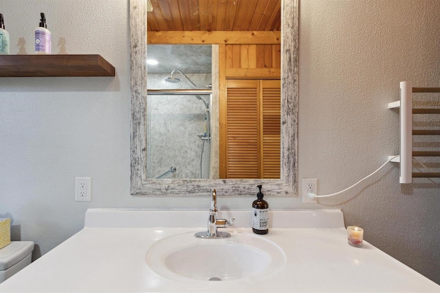 bathroom featuring vanity, a shower with shower door, toilet, and wood ceiling