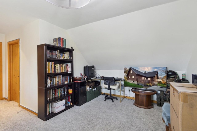 carpeted home office with vaulted ceiling