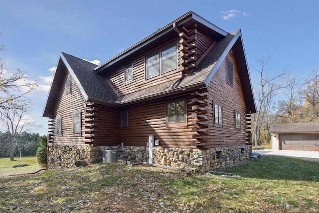 view of side of home with central air condition unit, an outdoor structure, a yard, and a garage