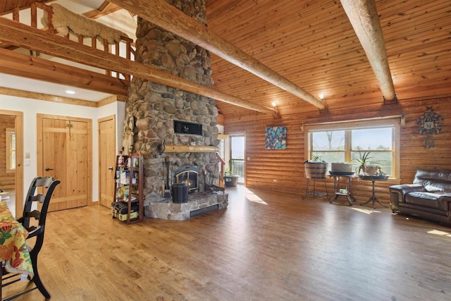 living room featuring a fireplace, log walls, wood ceiling, light hardwood / wood-style floors, and beam ceiling