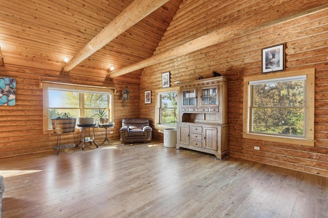 unfurnished room featuring hardwood / wood-style flooring, beamed ceiling, wooden ceiling, high vaulted ceiling, and rustic walls