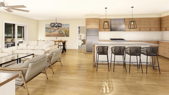 kitchen with stainless steel fridge, light wood-type flooring, pendant lighting, and a breakfast bar