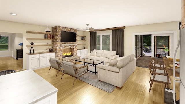 living room with ceiling fan, a stone fireplace, and light hardwood / wood-style flooring