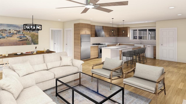 living room featuring ceiling fan with notable chandelier, sink, and light hardwood / wood-style floors