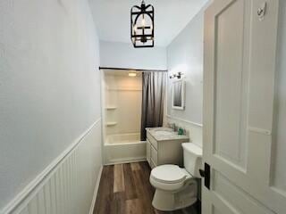 full bathroom featuring vanity, bathtub / shower combination, hardwood / wood-style flooring, a notable chandelier, and toilet