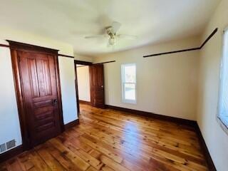 unfurnished bedroom featuring ceiling fan and dark hardwood / wood-style flooring