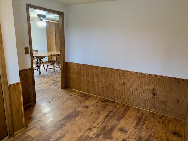 N8709 5th Ave, Camp Douglas, WI 54618 - spare room with a wainscoted wall, wood finished floors, wooden walls, and a ceiling fan