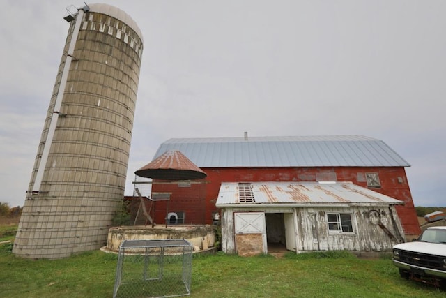 back of property featuring an outbuilding and a lawn