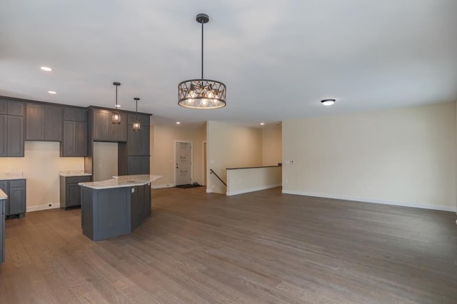 1003 E 10th St, Merrill, WI 54452 - kitchen featuring recessed lighting, a center island, baseboards, wood finished floors, and pendant lighting