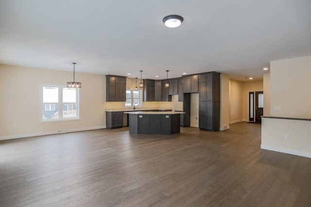 1003 E 10th St, Merrill, WI 54452 - kitchen featuring open floor plan, a center island, dark wood-type flooring, a sink, and recessed lighting