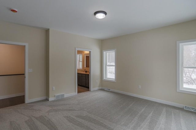 1003 E 10th St, Merrill, WI 54452 - unfurnished bedroom featuring carpet flooring, multiple windows, and baseboards