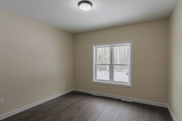 1003 E 10th St, Merrill, WI 54452 - spare room featuring baseboards and dark wood-type flooring