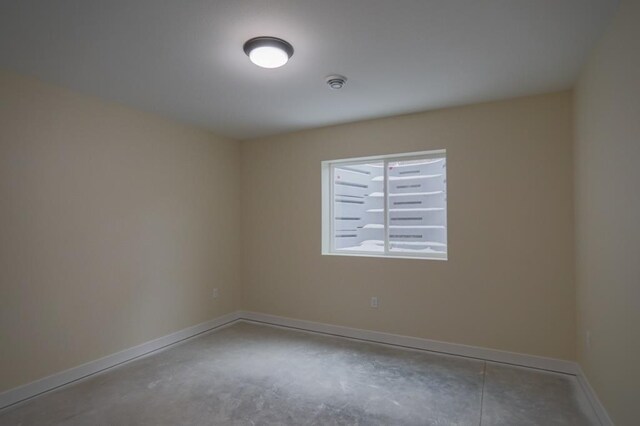 1003 E 10th St, Merrill, WI 54452 - spare room featuring unfinished concrete floors and baseboards