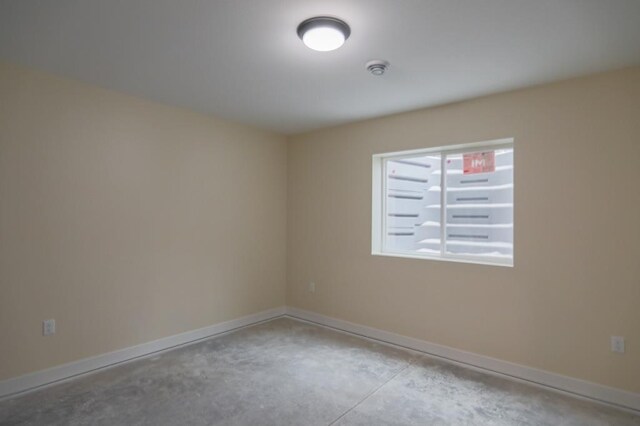 1003 E 10th St, Merrill, WI 54452 - empty room featuring concrete flooring, baseboards, and a smoke detector