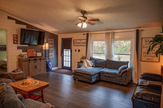 living room featuring lofted ceiling, ceiling fan, dark wood-type flooring, and a textured ceiling