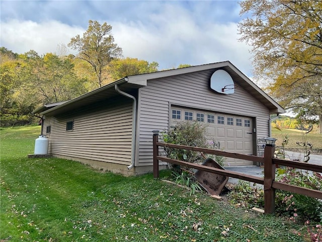 view of side of property featuring a garage and a lawn