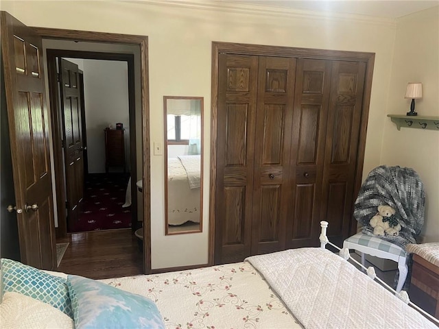 bedroom with ornamental molding, a closet, and dark hardwood / wood-style flooring