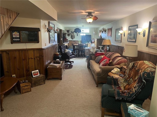 carpeted living room with wooden walls and ceiling fan