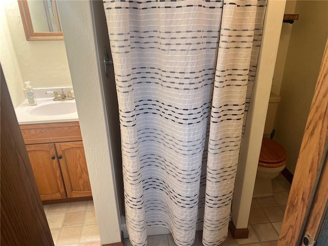 bathroom featuring a shower with shower curtain, vanity, toilet, and tile patterned floors