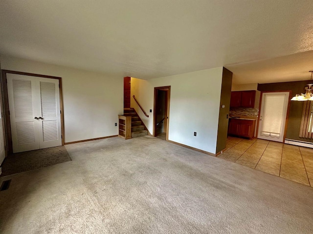 unfurnished living room with a textured ceiling, a chandelier, light colored carpet, and baseboard heating