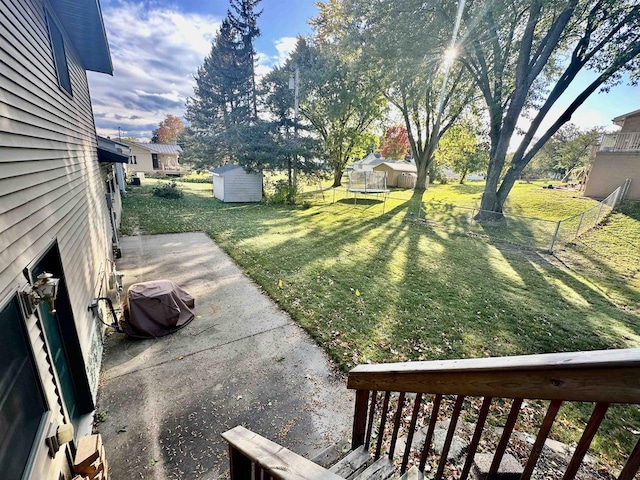 view of yard featuring a patio, a shed, and a trampoline