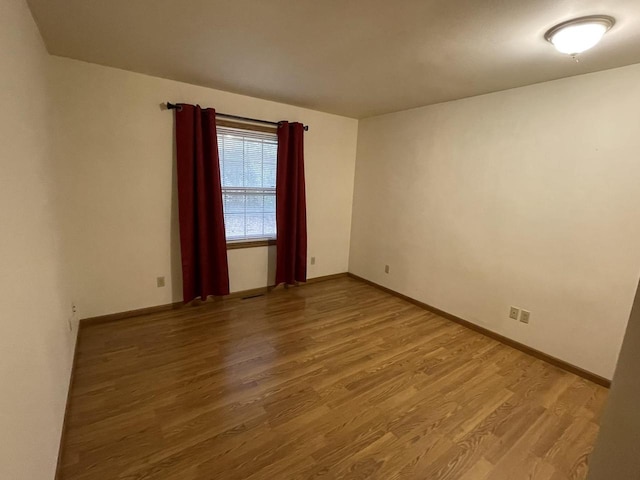 unfurnished room with hardwood / wood-style floors