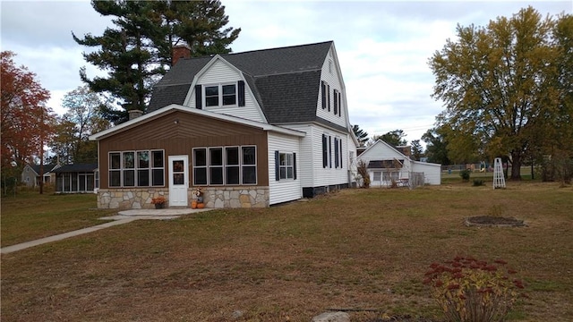 view of front of property featuring a sunroom and a front lawn