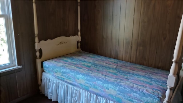 bedroom featuring wood walls