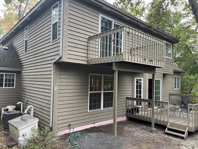 back of house featuring cooling unit and a deck