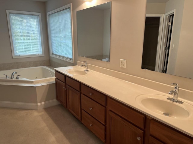 bathroom featuring a relaxing tiled tub and vanity